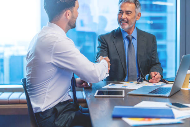 istock Two businessmen meeting with technology. One man has a laptop computer 1541095793