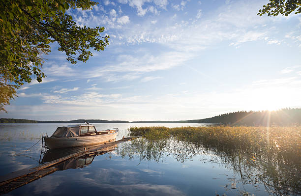 A motorboat at a jetty at sunset on a calm evening in Kimito island, Finland.