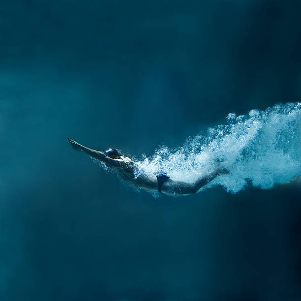 natação subaquática após o salto sobre fundo azul - bubble swimming pool water underwater - fotografias e filmes do acervo