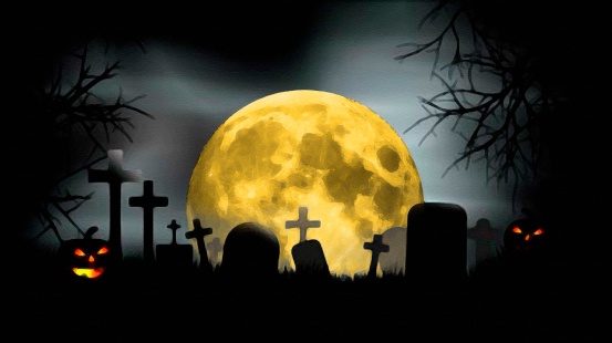 Full moon at creepy cemetery with evil looking pumpkins at Halloween night
