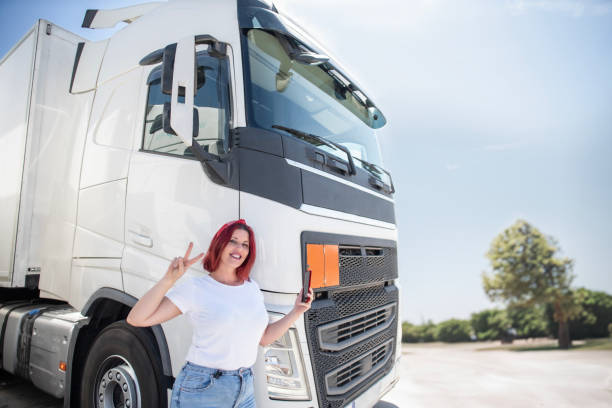 istock Trucker lifestyles, Red-haired trucker woman works with orders. Using technology and applications for delivery 1541123278