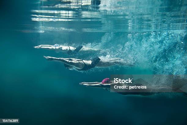Three Swimmers Underwater Divining After Start Stock Photo - Download Image Now - Swimming, Sports Team, Sport