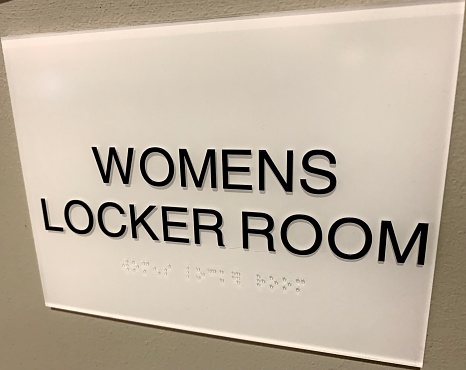 Accessible fitness facility locker room with braille signage.