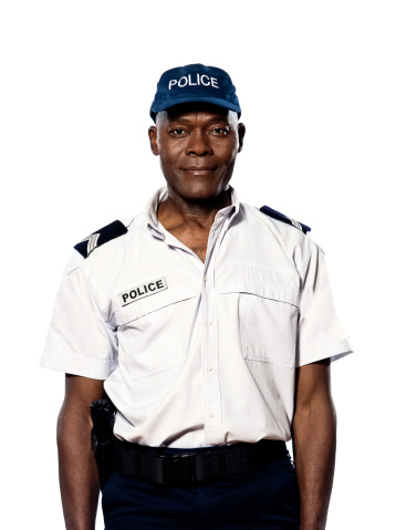 Portrait of an afro american african mature police officer standing in studio  isolated on white background