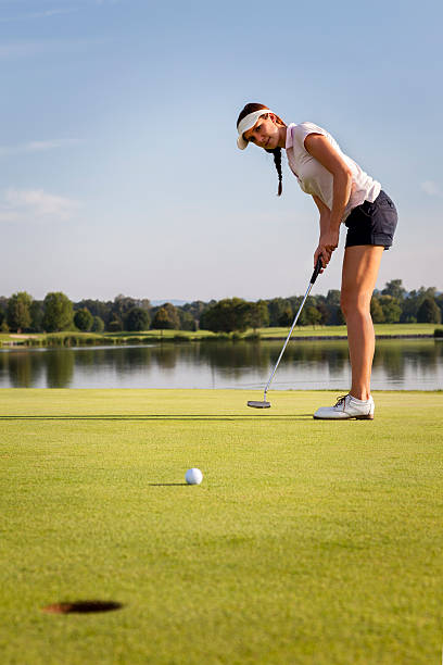 dziewczyna golfista wprowadzenie piłka na zielone. - putting golf golfer golf swing zdjęcia i obrazy z banku zdjęć