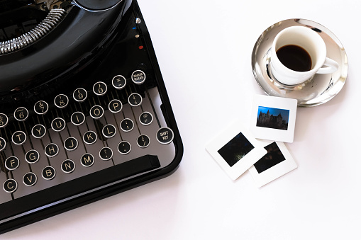 Flat lay view of mechanical typewriter with espresso and film slides