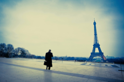 The Tour Eiffel in Paris, man walking by, tilt and shift lens.