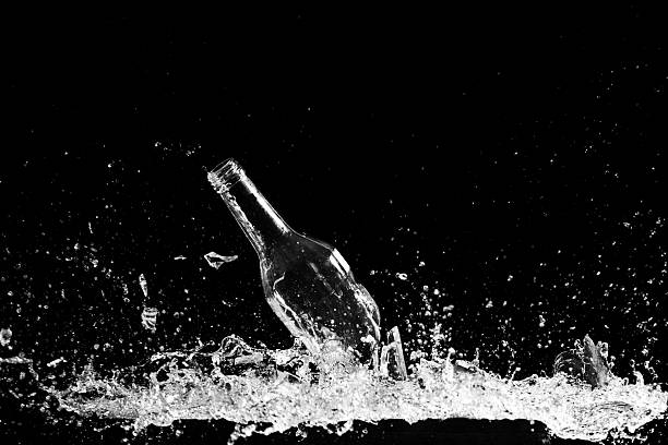 istock Clear glass bottle being broken on a black background 154130275