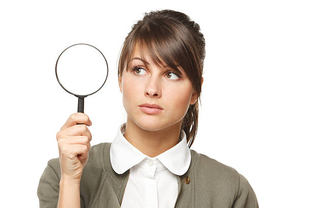 Calm female looking through magnifying glass