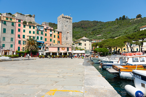 Porto Venere Italy - April 27 2011; Waterfront dock with boast strens tied-off with terrace homes and castle building.