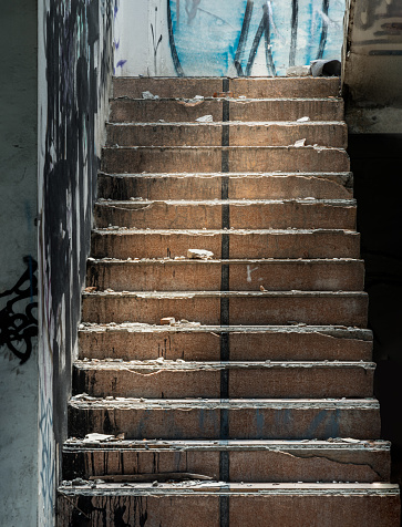 Bangkok, Thailand - Jul 08, 2023 - The old cement staircase and the graffiti patterns on cement wall is in the abandoned building and was left to deteriorate over years. Selective focus.