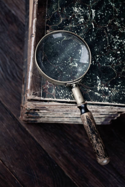istock Old vintage magnifying glass with books on table 1541361398