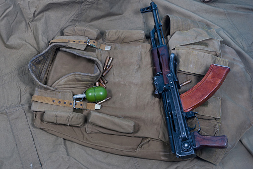 Kalashnikov AK 47 assault rifle with primitive russian body armor and steel helmet with ammunition