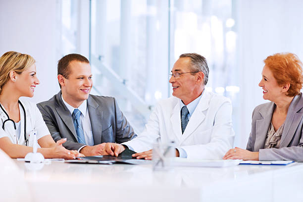 médico colaborar con un equipo de negocios - exam business caucasian board room fotografías e imágenes de stock