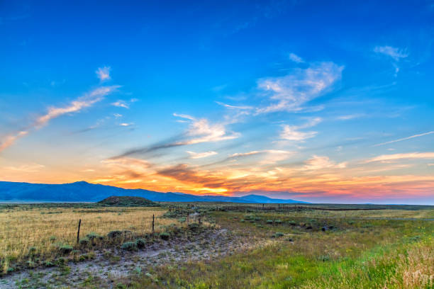 A beautiful colorful sunset beyond a large ranch in southern Wyoming just north of the Colorado state line.