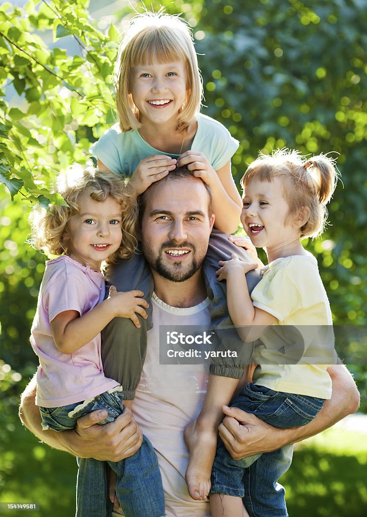 Dad with kids Happy family having fun outdoors in spring park against natural green background Adult Stock Photo