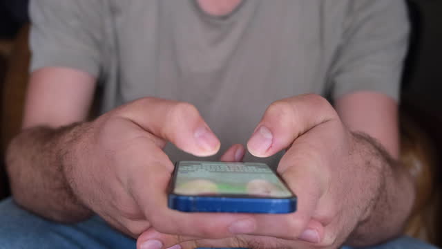 Fingers of a man texting on a smartphone device - close up slow motion