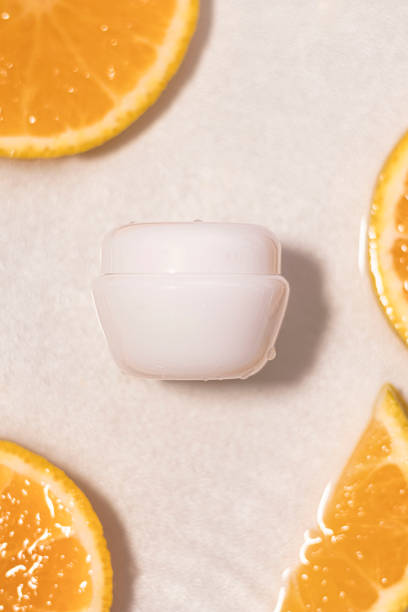 istock Unlabeled white bottle in water with white background and split oranges 1541532726