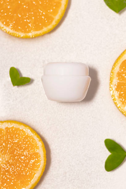 istock Unlabeled white bottle in water with white background, split oranges and green leaves 1541533255