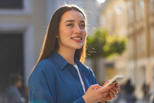 istock Young woman using smartphone typing text messages looking for a way on map in mobile navigator app 1541563166