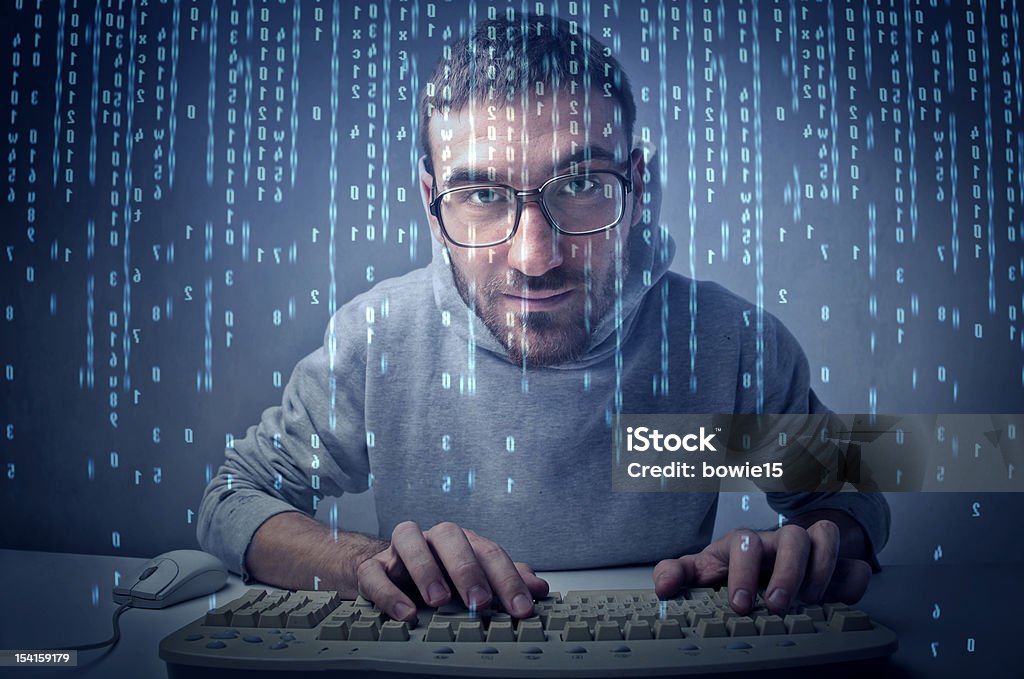 Binary code Young man typing on a computer keyboard with binary code passing on the screen Adult Stock Photo