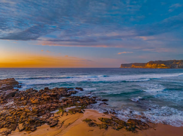 istock Ocean sunrise with rock platform and clouds 1541611625
