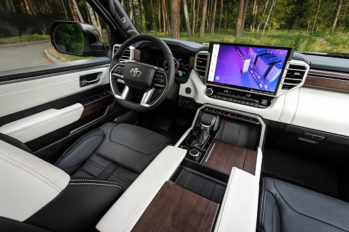 Novosibirsk, Russia - July  13, 2023:  white Toyota Tundra,  steering wheel, shift lever and dashboard, climate control, speedometer, display. Salon of a new stylish car