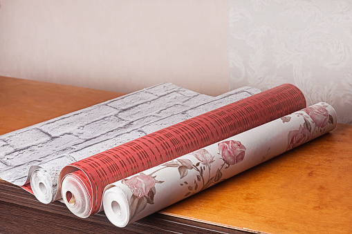 Rolls of multi-colored wallpaper for apartment renovation. You need to repair the apartment with the help of wallpaper.
