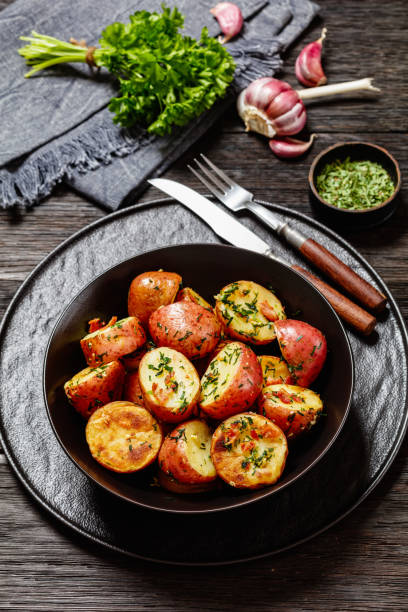 istock Herbs Garlic Potatoes in black bowl, top view 1541780563