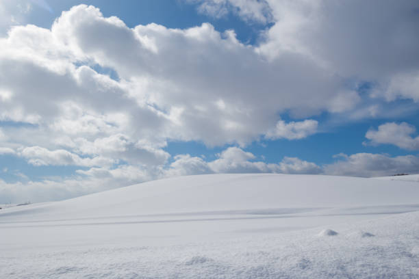 istock Snow on hill in winter with blue sky and white clouds 1541824561