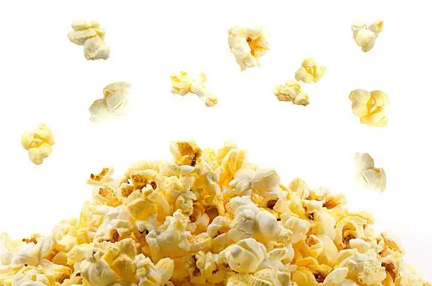 Close-up of popcorn popping isolated on white.