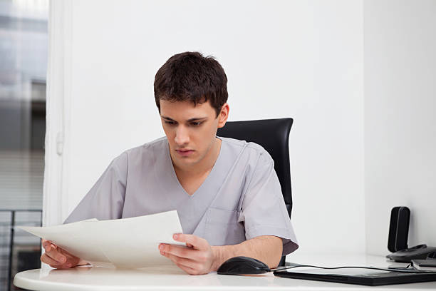 Doctor reading reports stock photo