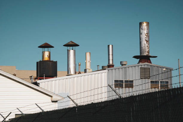 Chimney Industrial building roof with smokestacks and chimneys barbed wire wire factory sky stock pictures, royalty-free photos & images