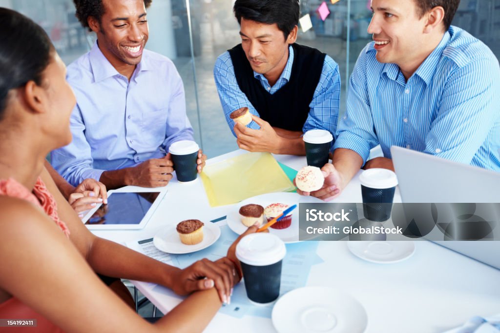 Refuelling for another brainstorming session A group of businesspeople having their tea break during a meeting Cupcake Stock Photo