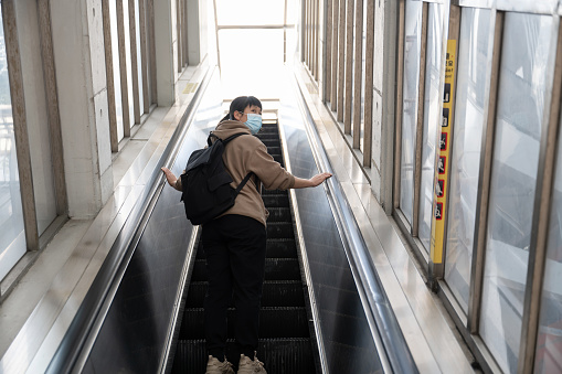 A female tourist is taking the escalator