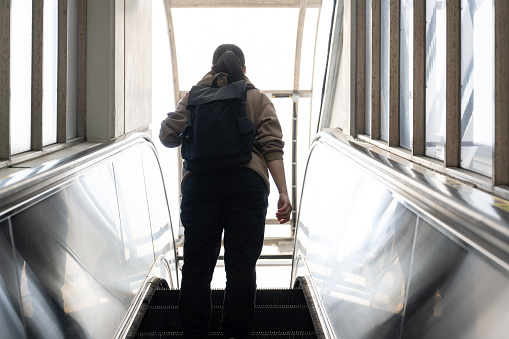 A female tourist is taking the escalator