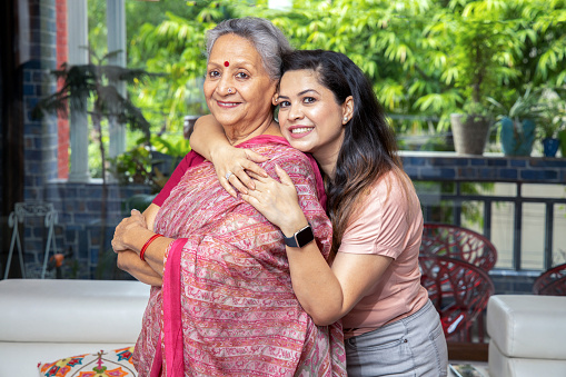 Happy young indian daughter hug her mother at home, Love and bonding, Asian family.