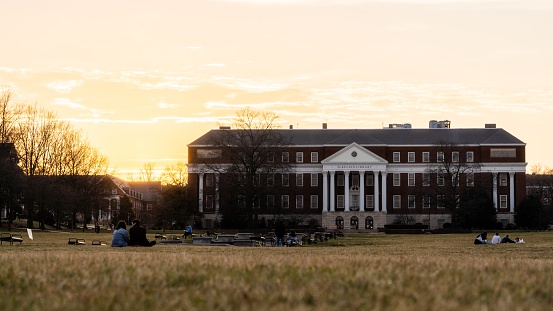 McKeldin Library in sunset at University of Maryland with students sitting on the lawn