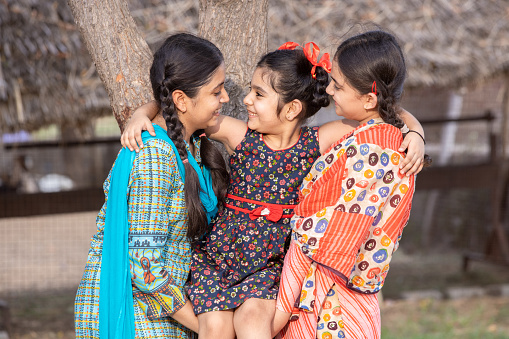 Portrait of cheerful rural indian girls kids playing together outdoor. Playful children.
