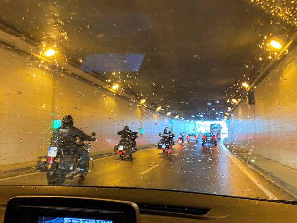 Motorcyclist on route in the rain stock photo