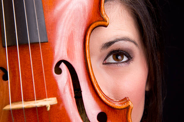 istock Female Face Eye Looks Up Behind Violin Stringed Musical Instrument 154204519
