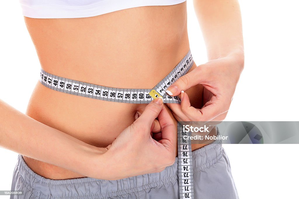 woman measuring her waistline Cropped image of a fit young woman measuring her perfect waistline Abdomen Stock Photo