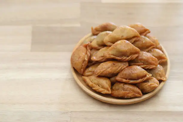 Photo of Thai snack ,Pun sib dried in a bowl on wooden background, (Thai Traditional Dessert)