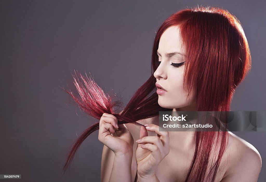 Young girl and haircare Beautiful, young girl is taking care of her hair Adult Stock Photo