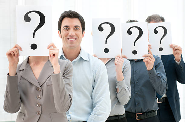 istock Row of people holding question marks over their faces 154208051