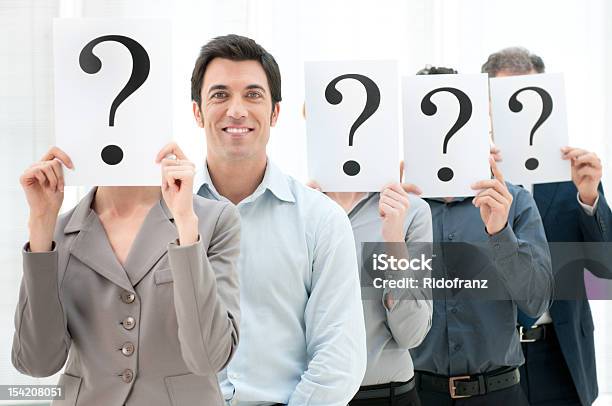 Row Of People Holding Question Marks Over Their Faces Stock Photo - Download Image Now