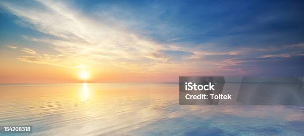 Pastel Sunset Over The Ocean In A Cloudy Sky Stock Photo - Download Image Now - Sunset, Sea, Sky