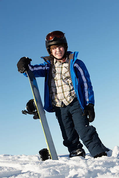 istock Young Boy With Snowboard On Ski Holiday In Mountains 154210415