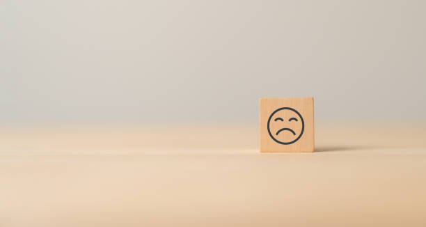 istock Unhappy face emoticon on wooden cube blocks.Customer dissatisfaction experience. Bad experience, bad review, bad service, dislike, bad quality, low rating. Service rating, satisfaction concept. 1542115012