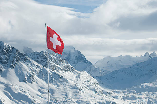 Swiss flag in the Engadin Focused on the Swiss flag in the background Engadine mountains, Switzerland engadine stock pictures, royalty-free photos & images